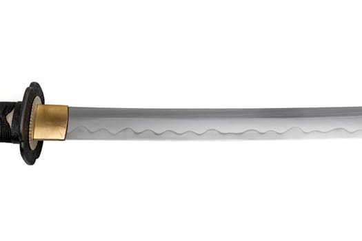 The Habaki - collar is made of polished brass. It is at the base of a Japanese sword blade with a wavy pattern on the sharp part. isolated on a white background. Selective focus.