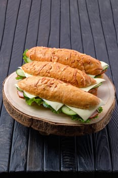 Hunter's sandwich with ham, cucumber, cheddar cheese on wooden board