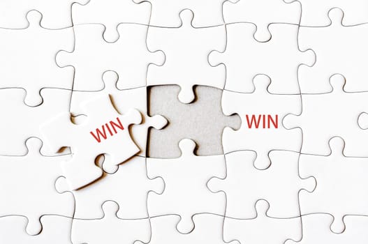 Missing jigsaw puzzle piece completing word WIN WIN. Business concept image for completing the final puzzle piece.