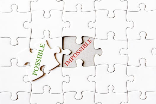 Missing jigsaw puzzle piece with word POSSIBLE, covering text IMPOSSIBLE. Business concept image for completing the final puzzle piece.