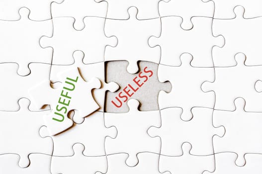 Missing jigsaw puzzle piece with word USEFUL, covering text USELESS. Business concept image for completing the final puzzle piece.