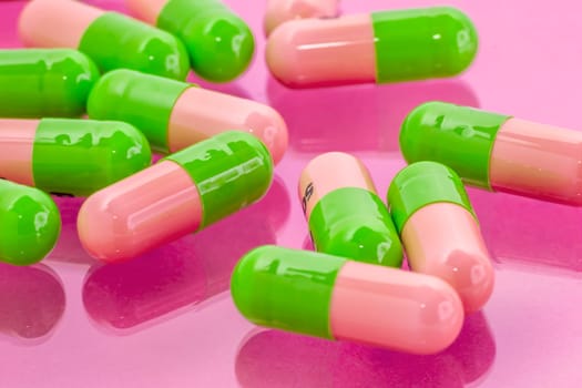 several pink-green pills spilling on the table