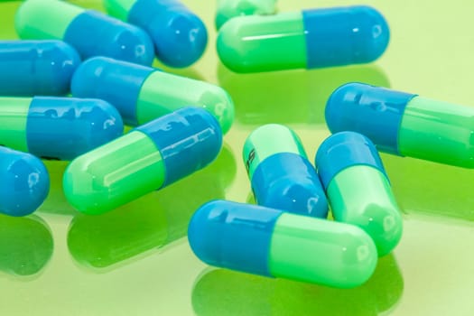 several blue-green pills spilling on the table