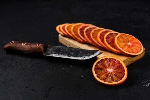Overhead view of slices of blood orange on black background