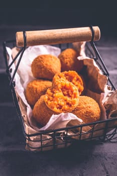 Homemade Arancini - deep fried rice balls stuffed with Mozzarella cheese in basket