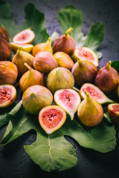 Harvesting - tasty organic figs on black background
