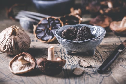 Truffles and shiitake mushrooms and spices on kitchen table
