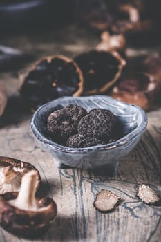 Truffles and shiitake mushrooms and spices on kitchen table