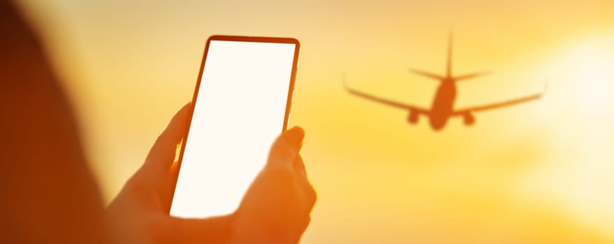 Woman hands holding smartphone at outdoors in the evening. Close-up view. Concept of the tourism and journey.