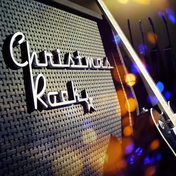 Guitar amplifier with a chrome badge Christmas Rock and blurred Christmas lights, 3d rendering