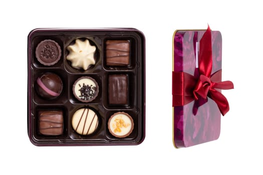 Closeup of box of fine chocolate candies in a beautiful plastic box isolated on a white background. Surprise gift for Valentine's Day or other festive occasions. Macro.
