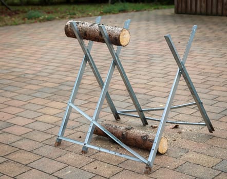 Details of a sawhorse with log and saw at a wedding.