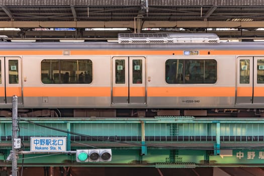 tokyo, nakano - dec 25 2020:Nakano Station railway platform surrounding by a JR Chuo Line train with passengers inside.