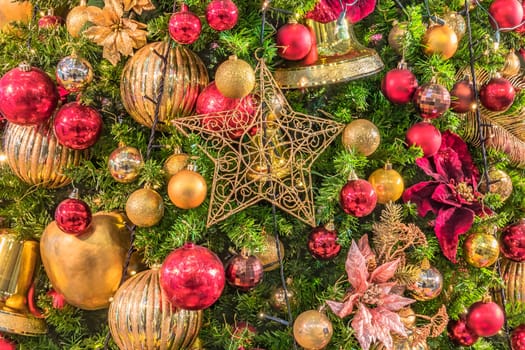 Background of Christmas tree ornament lights with glitter decoration balls in foreground.
