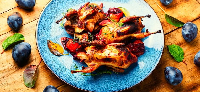 Roasted tasty quail in plum sauce. Meat with plum.
