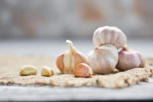 Garlic cloves and bulbs on wooden cutting board (photo with shallow depth of field)