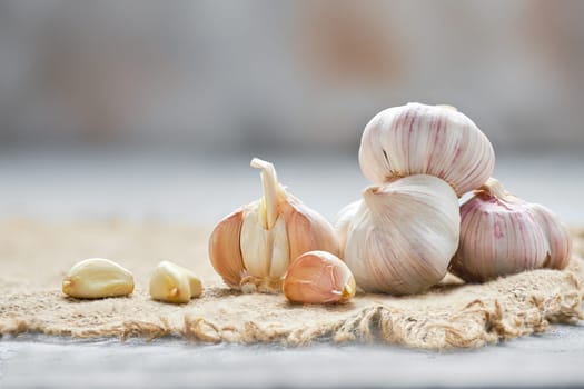 Garlic cloves and bulbs on wooden cutting board (photo with shallow depth of field)