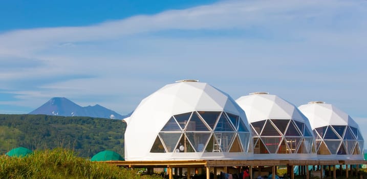 The Glamping house  and volcano, rural landscape, tent houses in Kamchatka peninsula. Selective focus.