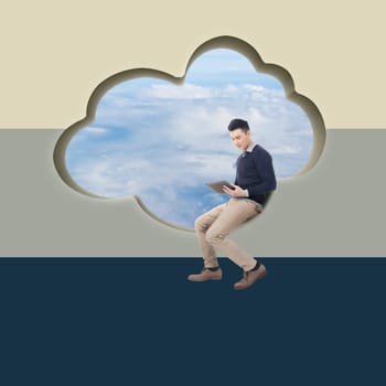 Cloud concept with man sit at a cloud shaped wall and using tablet.