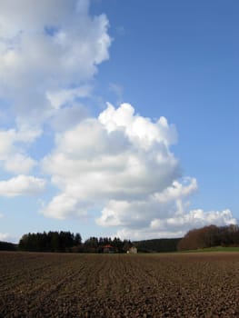 Field with house and cloud sky
