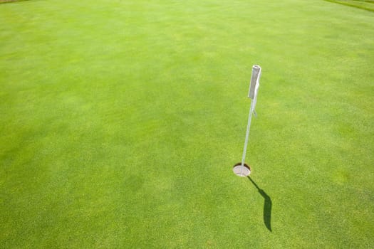 Golf practice putting green with flagstick hole