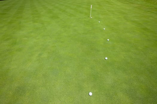 Golf putting green with balls on predicted line to hole