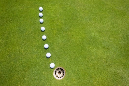 Golf putting green with balls on predicted line to hole