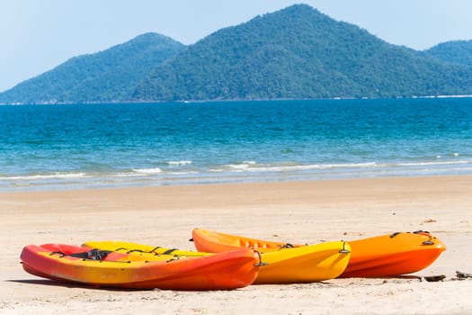 Kayak canoes on beach next to tropical blue ocean water at Mission beach south of Cairns Queensland Australia