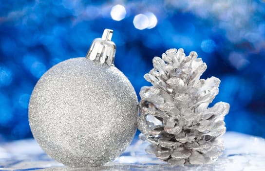 Silver christmas decoration with ball and cone on blue background