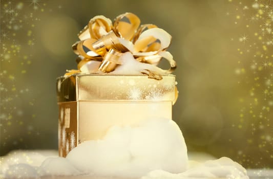 Golden Christmas background with present box on snow