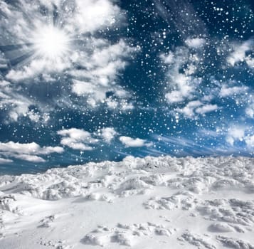 Winter landscape with snow covered hill and cloudy blue sky