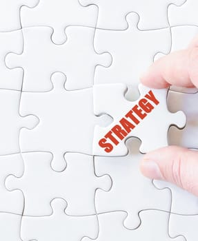 Missing jigsaw puzzle piece with word STRATEGY. Business concept image for completing the puzzle.