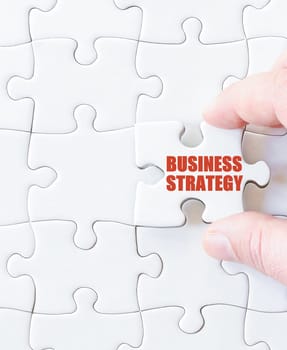 Missing jigsaw puzzle piece with word BUSINESS STRATEGY. Business concept image for completing the puzzle.