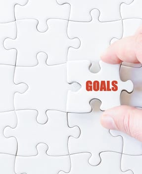 Missing jigsaw puzzle piece with word GOALS. Business concept image for completing the puzzle.