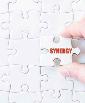 Missing jigsaw puzzle piece with word SYNERGY. Business concept image for completing the puzzle.