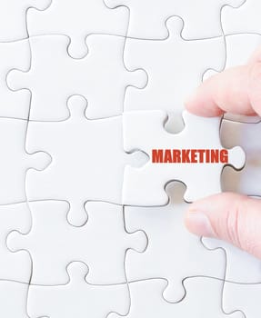 Missing jigsaw puzzle piece with word MARKETING. Business concept image for completing the puzzle.