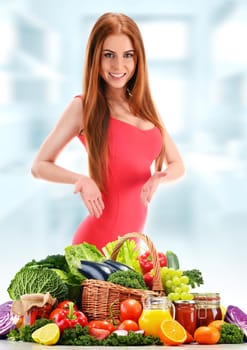 Wicker basket with assorted organic vegetables and fruits isolated on white