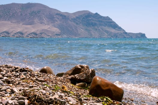 boulder on the coast is shooting close-up on a background of mountains