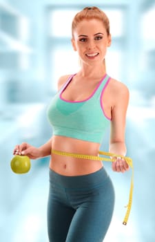 Young woman holding measure tape and apple. Weight loss.