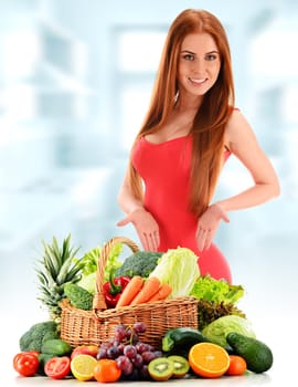 Young woman with variety of organic vegetables and fruits.