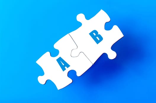 Connected puzzle pieces with letters A and B  isolated over blue background, with copy space available. Business concept image.