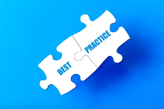 Connected puzzle pieces with text BEST PRACTICE  isolated over blue background, with copy space available. Business concept image.