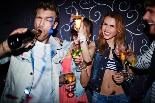 Group of clubbing friends with champagne having fun at party