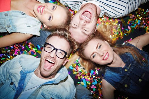 Group of joyful friends lying on the floor in nightclub