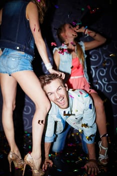 Ecstatic guy having fun with girls in night club
