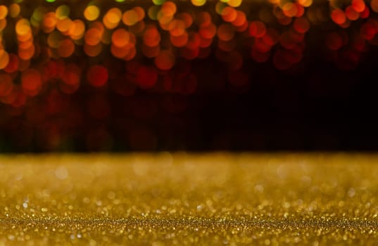 Golden glitter lights with abstract red bokeh on black background