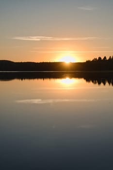 Sunset with reflection on a Swedish lake in Smalland. Romantic evening mood. Landscape shot from Scandinavia in nature