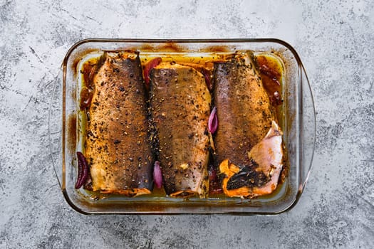 Top view of pan with red salmon baked in oven with spice