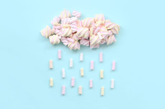 Marshmallow rain cloud on pastel light blue background. Cute metaphorical bad weather concept. Minimal flat lay top view