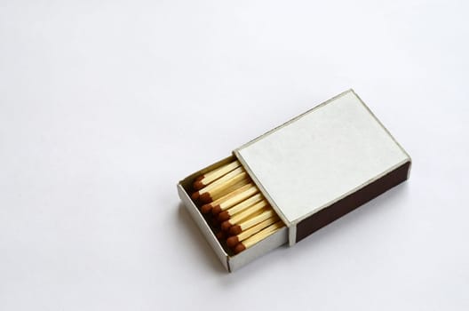 Open cardboard matchbox filled with matches on a white background. Flat lay minimal. Top view with text space